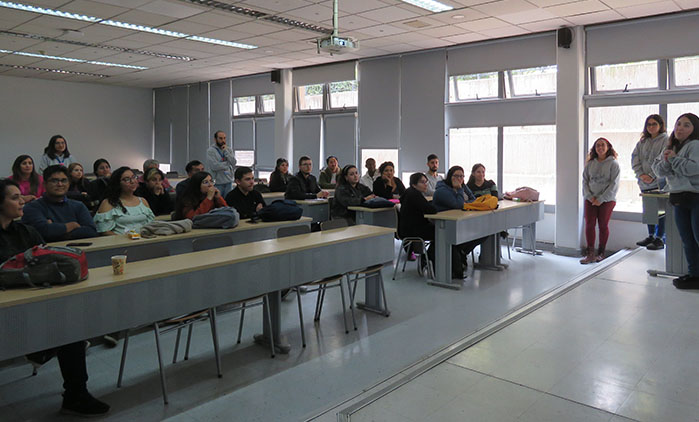Fotografía de un grupo de personas sentados en sala de clases