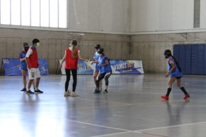 Equipos de estudiantes juegan partido de fútbol adaptado con vendas en los ojos.