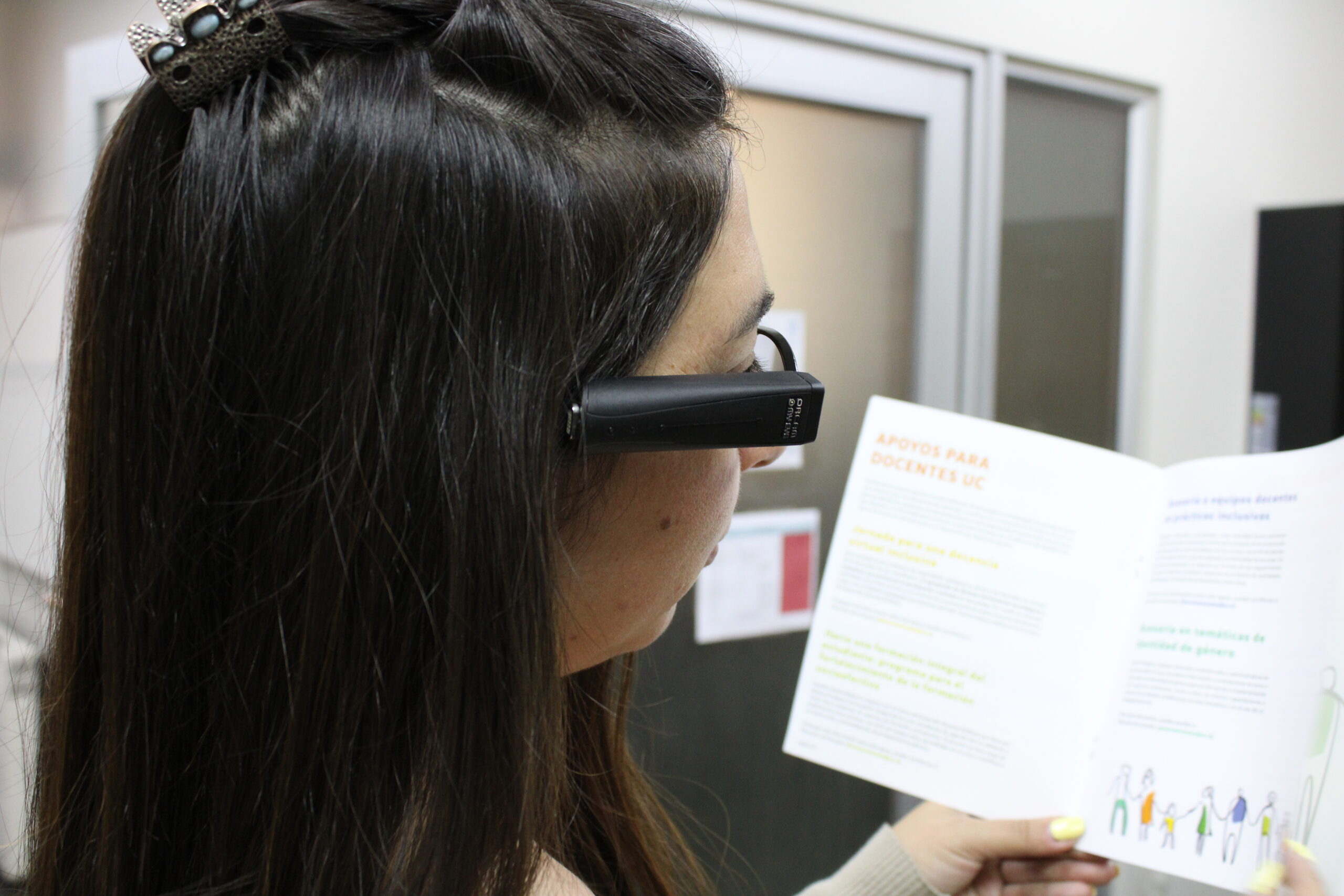 Persona utilizando el dispositivo Orcam para leer documento.