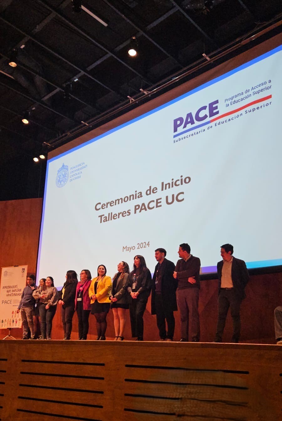 Profesionales equipo PACE UC posando en el escenario del auditorio durante ceremonia bienvenida Talleres PACE UC 