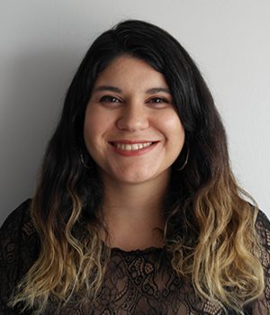 Foto facial de profesional de PACE UC y Graduación Efectiva, María Cecilia Hernández, con fondo gris.