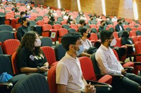 Decenas de estudiantes con mascarilla sentados poniendo atención a la Bienvenida de vías de equidad 2022