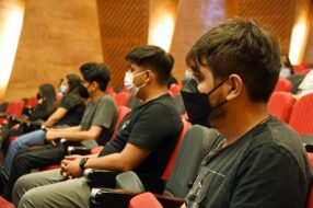 Estudiantes con mascarilla sentados poniendo atención a la Bienvenida de vías de equidad 2022