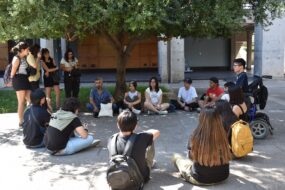 Foto de estudiantes UC reunidos y reunidas en un círculo