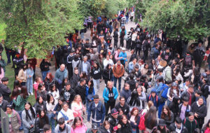 Fotografía de cientos de personas conversando y tiendo en un sector abierto