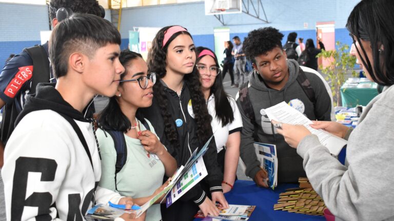 Estudiantes recibiendo información en stand PACE UC en Feria Vocacional Formando Futuro 2023