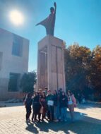 Estudiantes Liceos PACE UC posando abajo de estatua Cristo de Campus San Joaquín