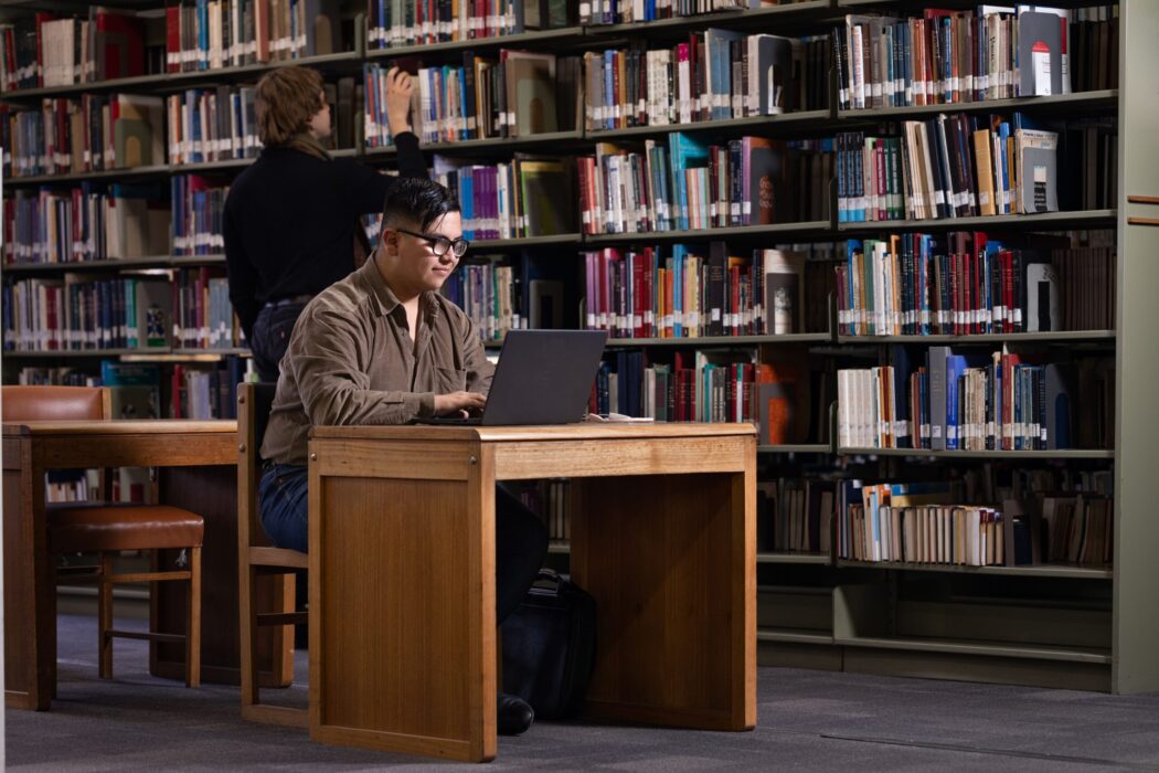 Estudiante sentado en un escritorio ocupando su computador